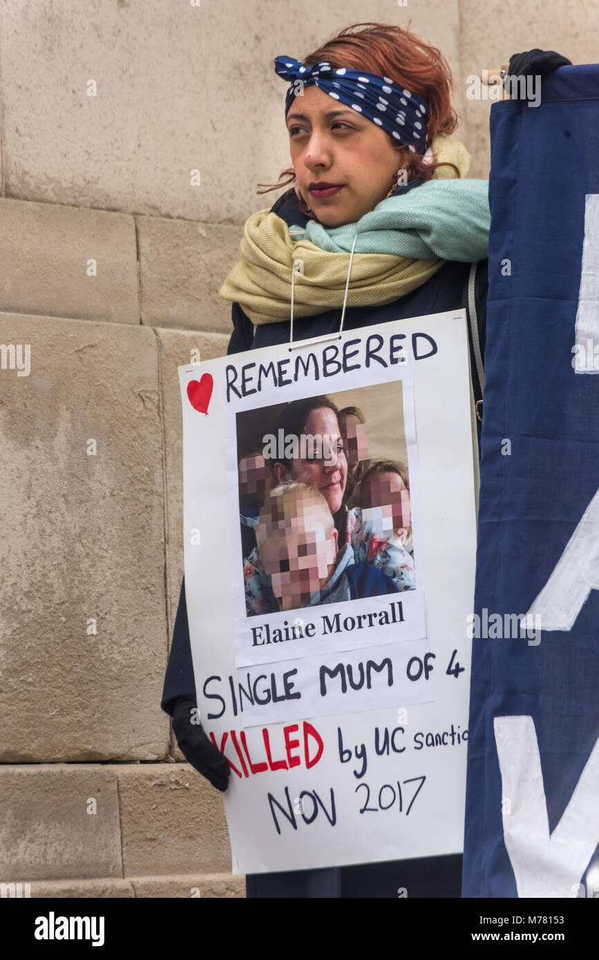 London, UK. 8th March 2018. A woman holds a poster about single 'mum of 4' Elaine Morrall kiled by Universal Credit sanctions in November 2017 at the Global Women's Strike mock trial of the Family Courts in an International Women’s Day protest in front of Parliament. Speakers included mothers who have had children unjustly removed and others who read out shocking comments made in court by judges. The UK has the highest rate of adoptions in Europe, almost all without consent of their birth family. In some working class areas, 50% of children are referred to social services and that families of  Stock Photo