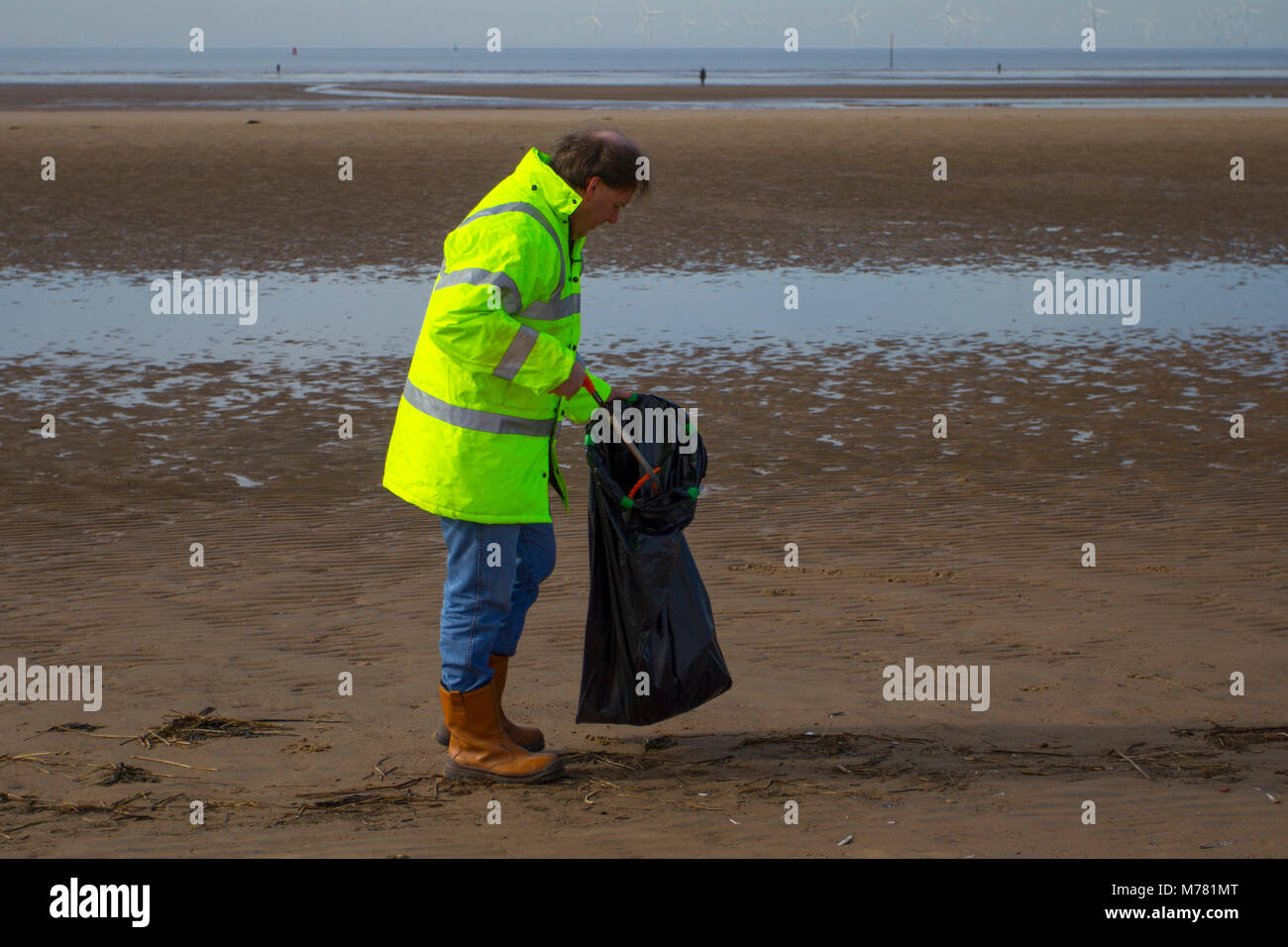 Crosby, Merseyside.  UK Weather. 9th March, 2018.  Network rail 'Social Responsibilty' volunteers beach cleaning at Mariners Way Beach. Employees are given five days' volunteer leave to help any UK registered charities of their choice or a community engagement activity. Squads of workers, who have to pay their own way to the resort, are employed to remove items washed up in the plastic tide brough to land by recent storms. Credit MediaWorldImages/AlamyLiveNews. Stock Photo
