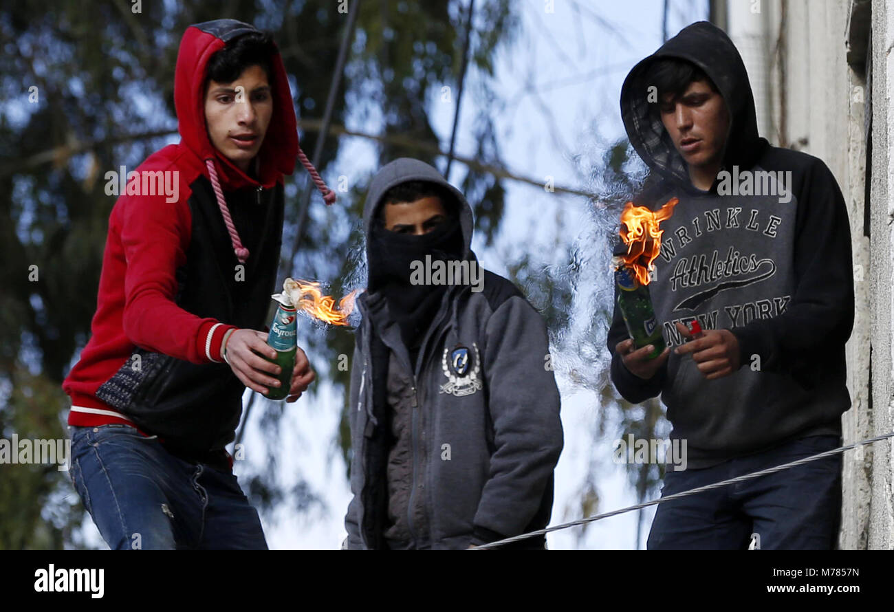 Hebron, West Bank, Palestinian Territory. 9th Mar, 2018. Palestinian boys prepare to throw molotov cocktails towards Israeli security forces during clashes against a decision by US President Donald Trump to recognise Jerusalem as the capital of Israel, in the West Bank city of Hebron on March 09, 2018 Credit: Wisam Hashlamoun/APA Images/ZUMA Wire/Alamy Live News Stock Photo