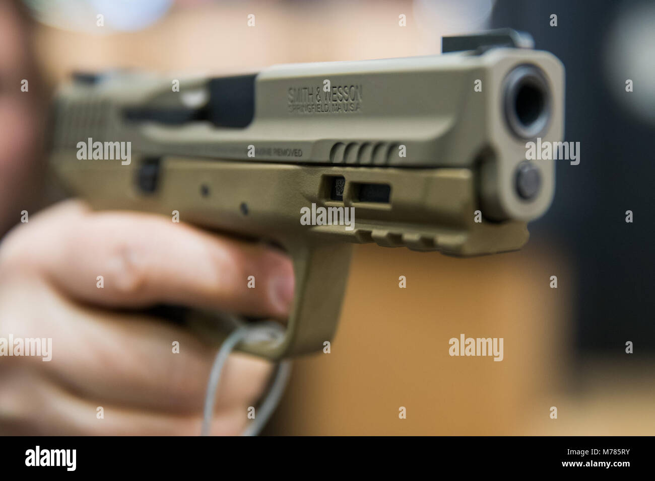 09 March 2018, Germany, Nuremberg: A woman holding a 9 millimetre handgun by the American manufacturer Smith & Wesson (S&W) at the IWA OutdoorClassics trade show for hunting, shooting sports, equipment for outdoor activities and for civilian and official security applications. Photo: Daniel Karmann/dpa Stock Photo