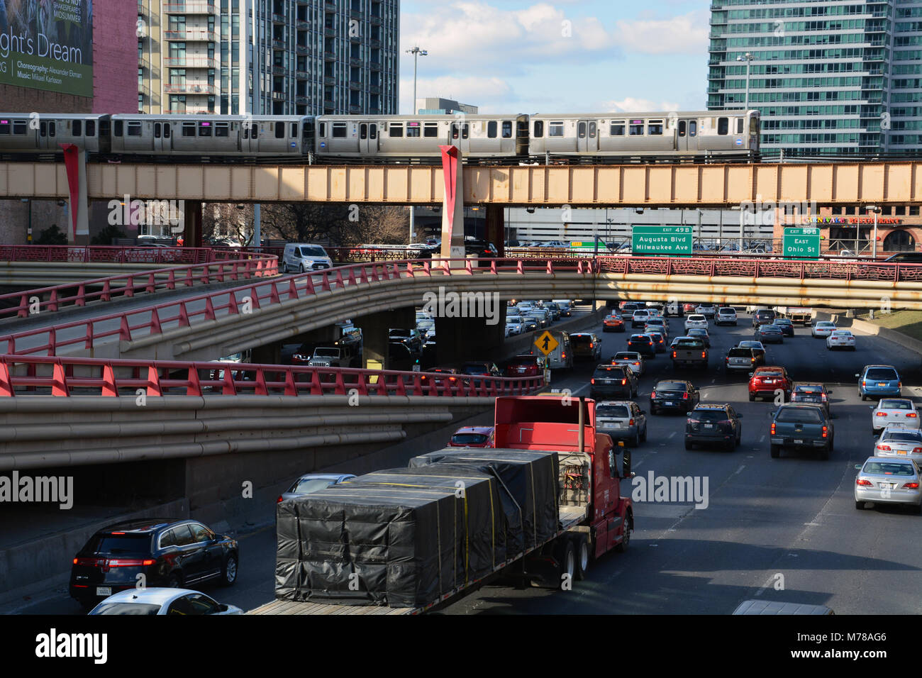 A CTA L train passes over the Kennedy Expressway, clogged with traffic, as the evening rush hour begins just west of downtown Chicago. Stock Photo