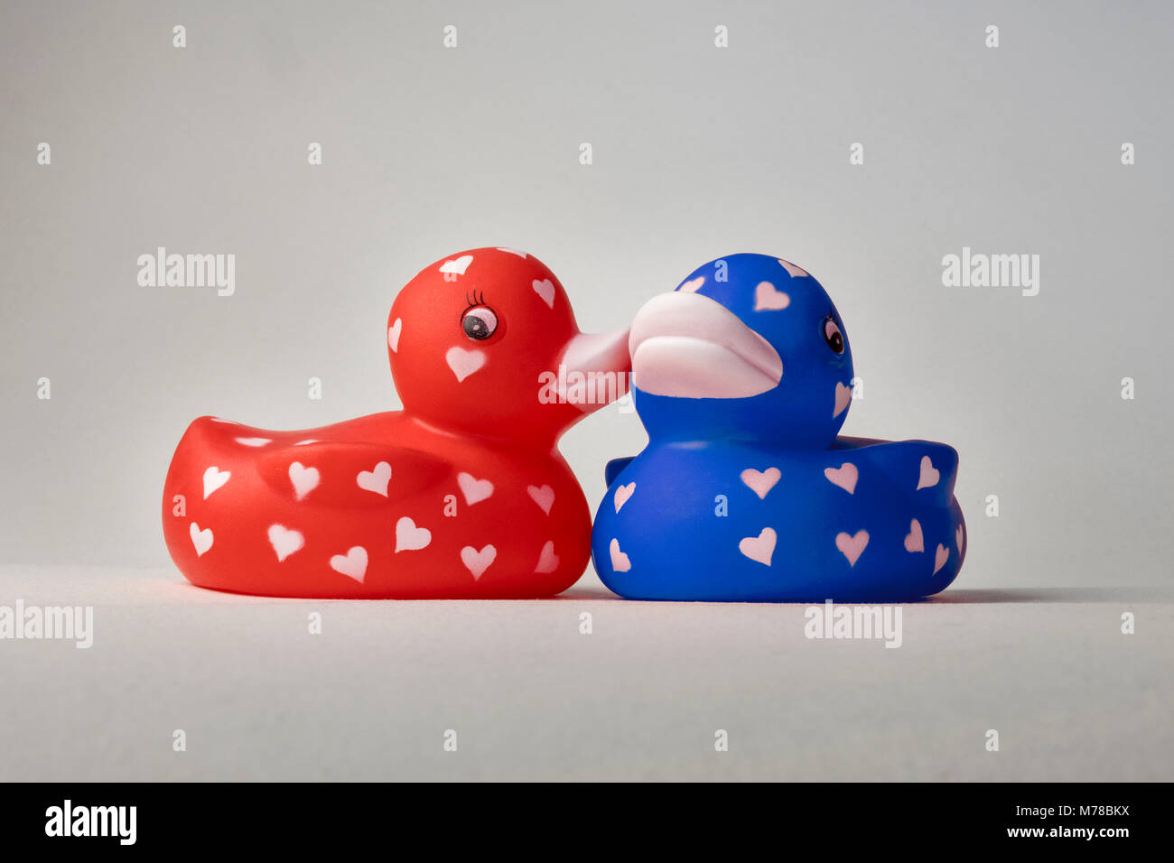 Valentine bath love ducks with hearts on their bodies, whispering, kissing on cheek Stock Photo