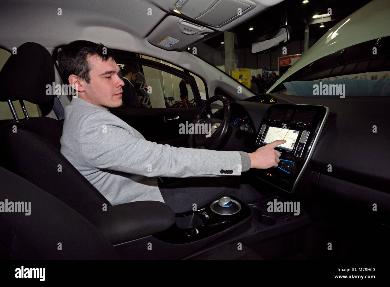 Driver manipulating a touch screen monitor in cabin of a new electric car. Exhibition PLUG-IN UKRAINE 2018. March 2, 2018. Kiev Ukraine Stock Photo
