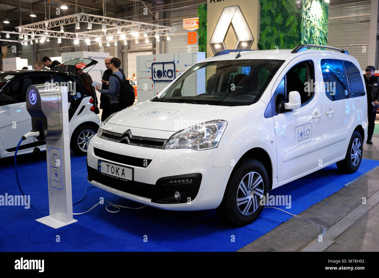 Electric vehicle charging by electric car charger. Exhibition PLUGIN