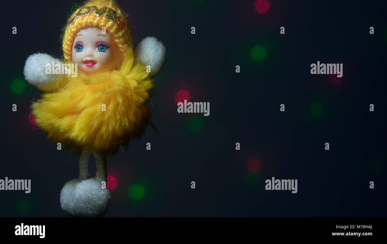 Cute yellow baby doll with dark background Stock Photo