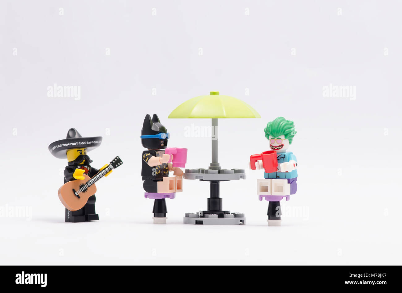 joker and batman sitting and having a drink with mariachi play the guitar  Stock Photo - Alamy