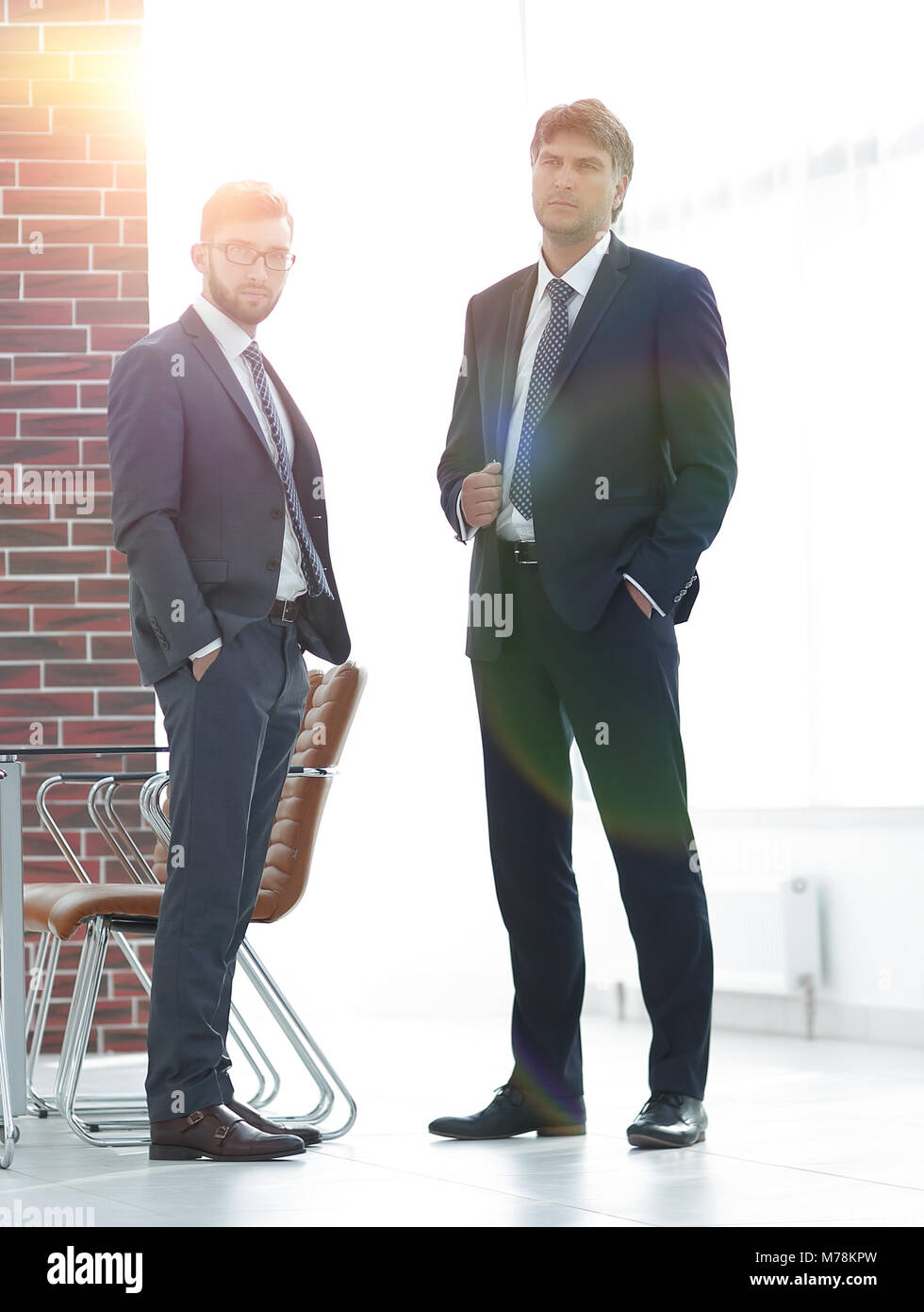 Two businessmen standing in a spacious modern office Stock Photo - Alamy