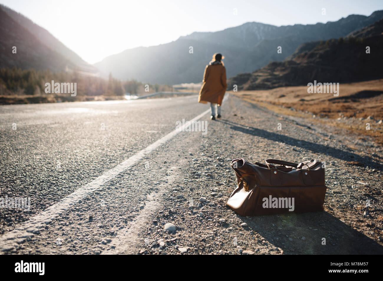 Bag near the road. Girl going out on the background Stock Photo