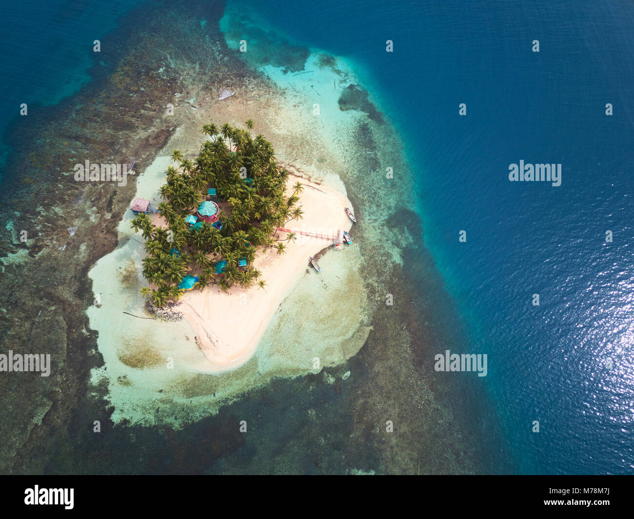 Small privat island on blue caribbean sea water aerial drone view Stock