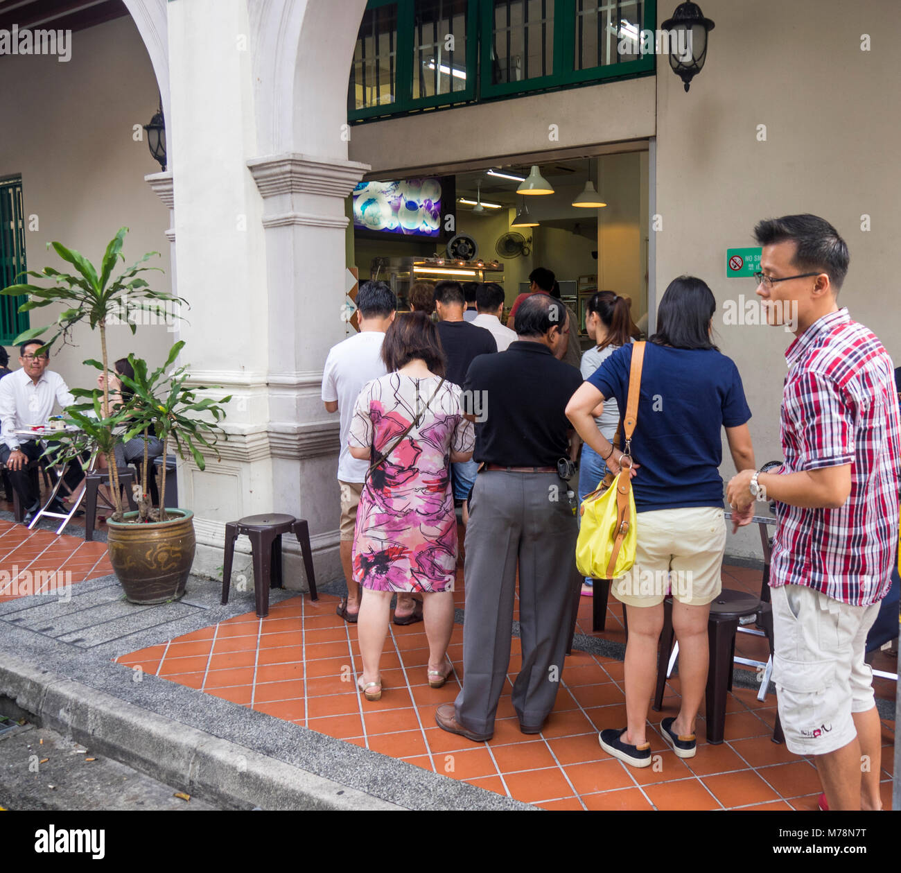 Local Singaporeans queuing out a popular traditional Singapore restaurant, YY Kafei Dian, for breakfast. Stock Photo