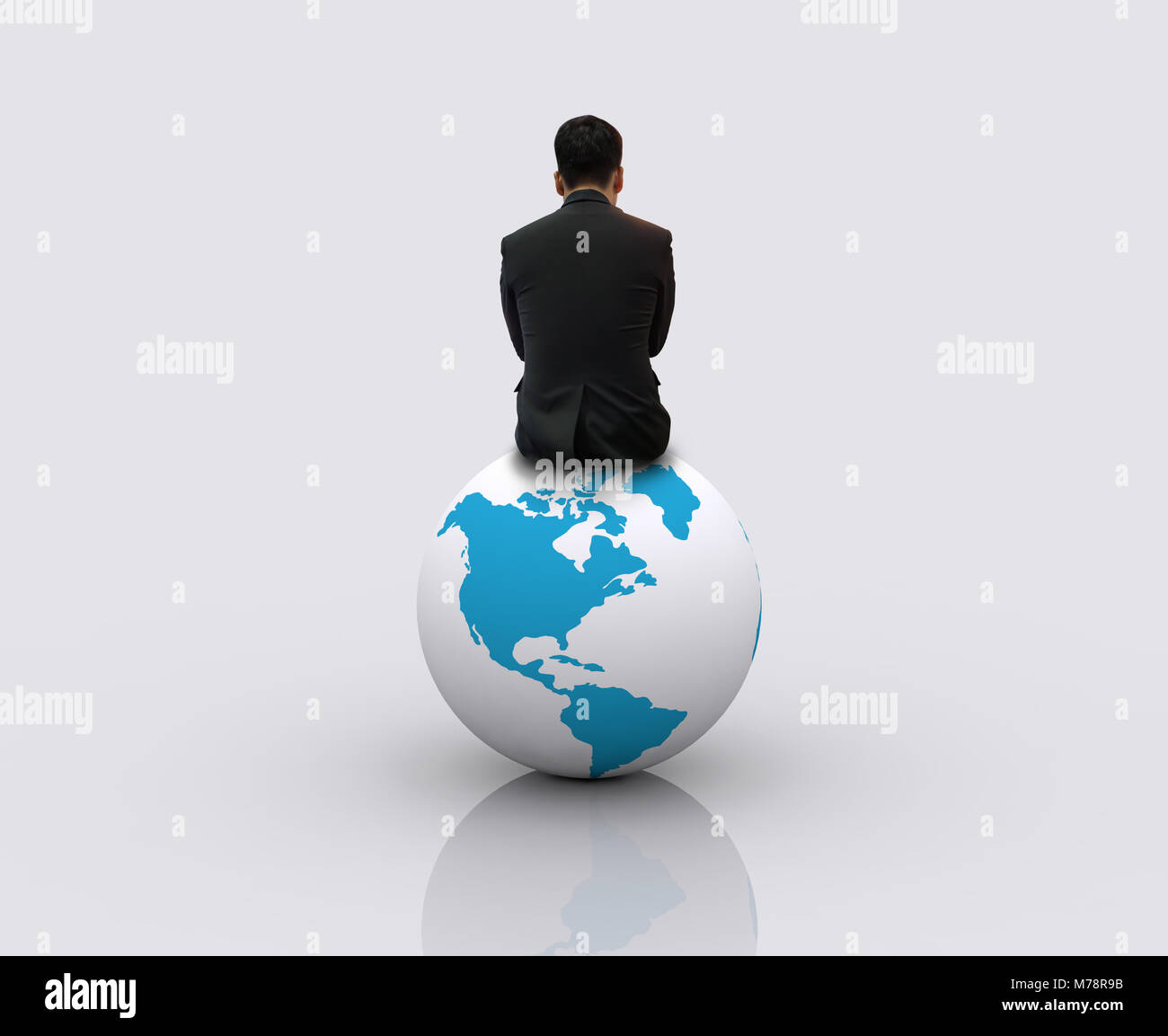 Businessman sitting on the globe Stock Photo