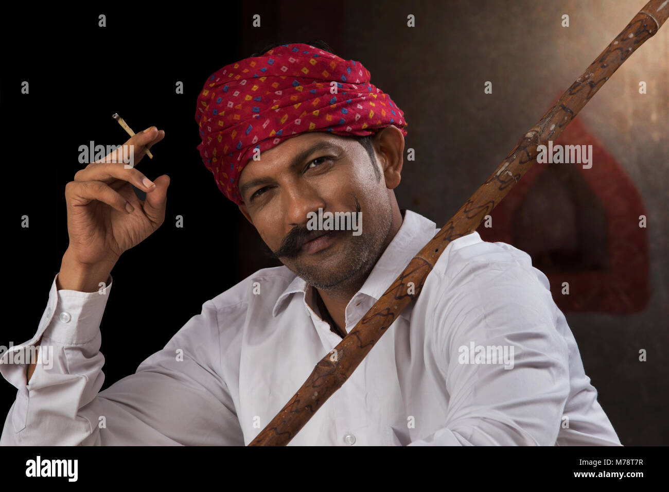 Farmer wearing turban and smoking cigar Stock Photo