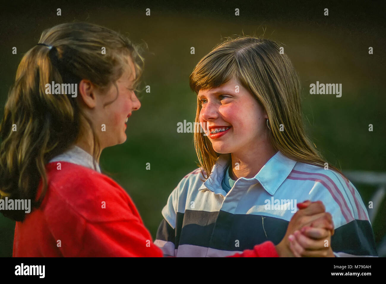 Two happy children at summer camp holding hands and smiling at each other. Stock Photo
