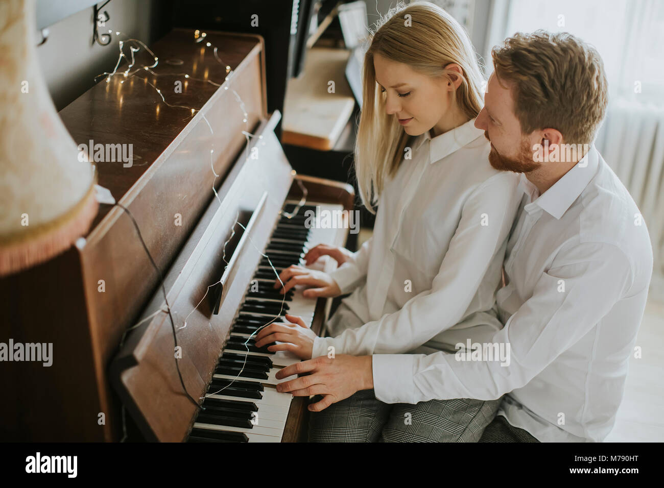 Loving couple playing piano in the room at home Stock Photo - Alamy