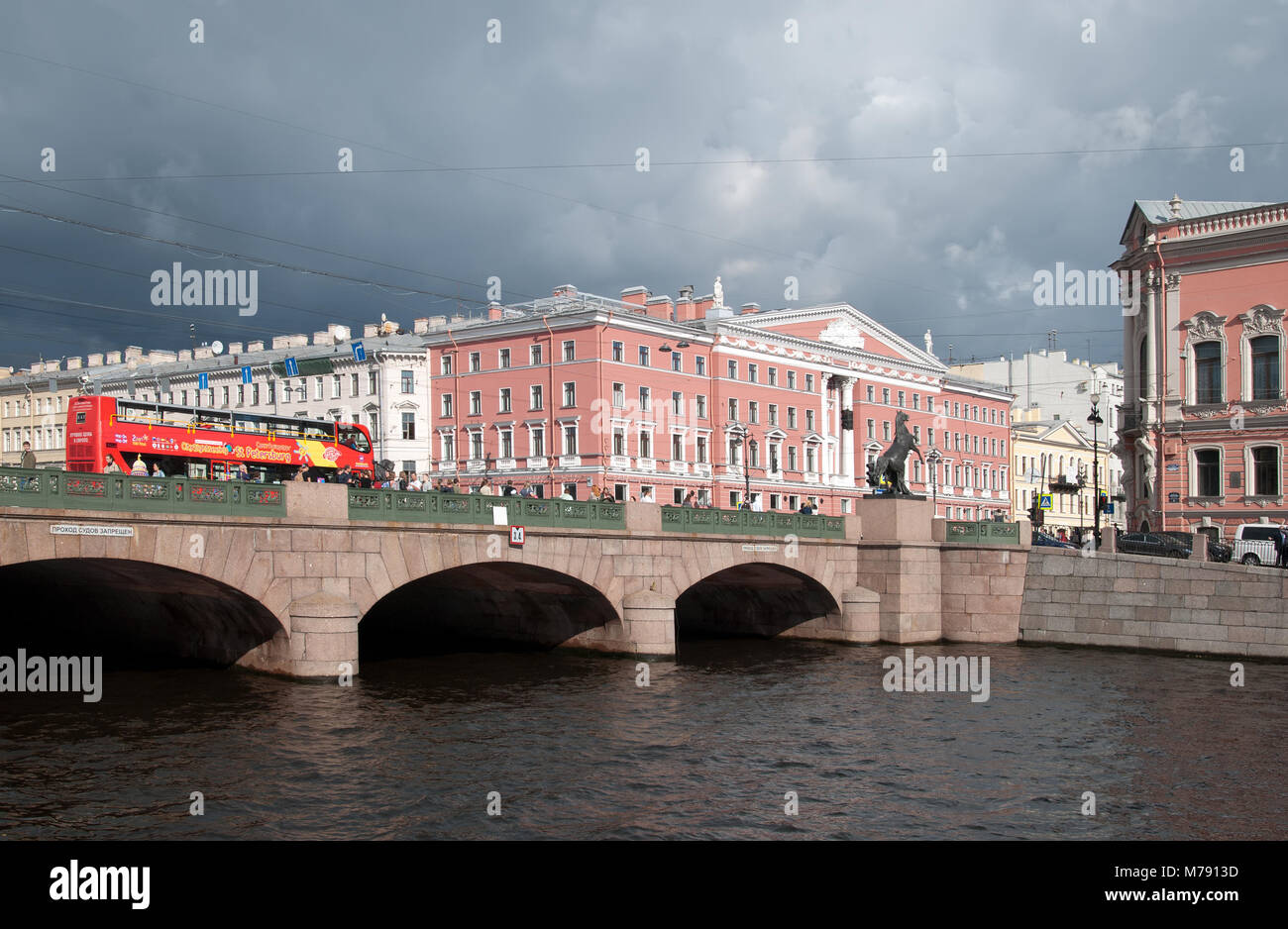 Hop-On Hop-Off. City Tour Bus rides on The Anichkov Bridge with The Horse Tamers by Peter Klodt across The Fontanka River near Nevsky Avenue Stock Photo