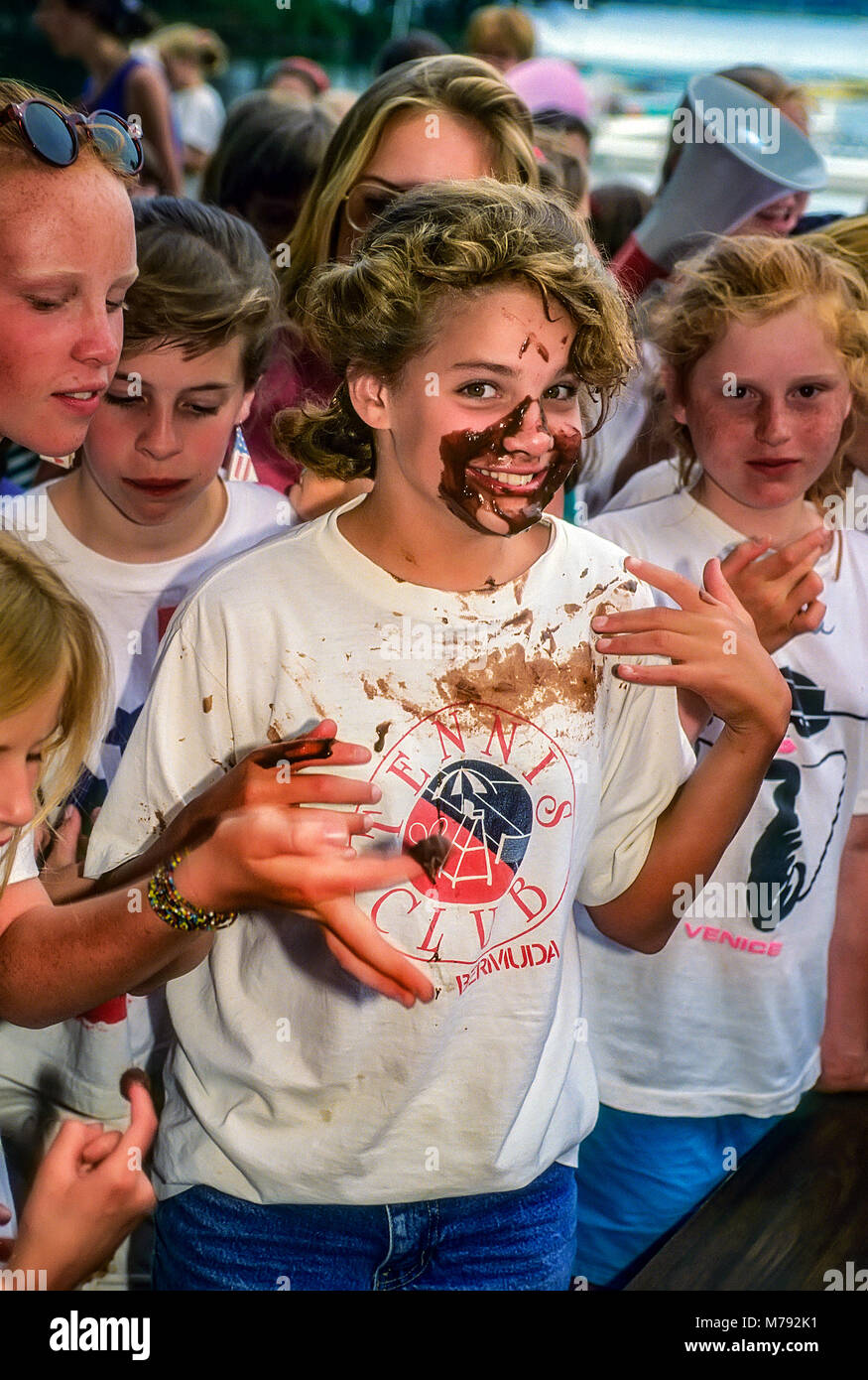 Happy children having fun smearing cake frosting over each other at summer camp in Vermont, United States, North America. Stock Photo