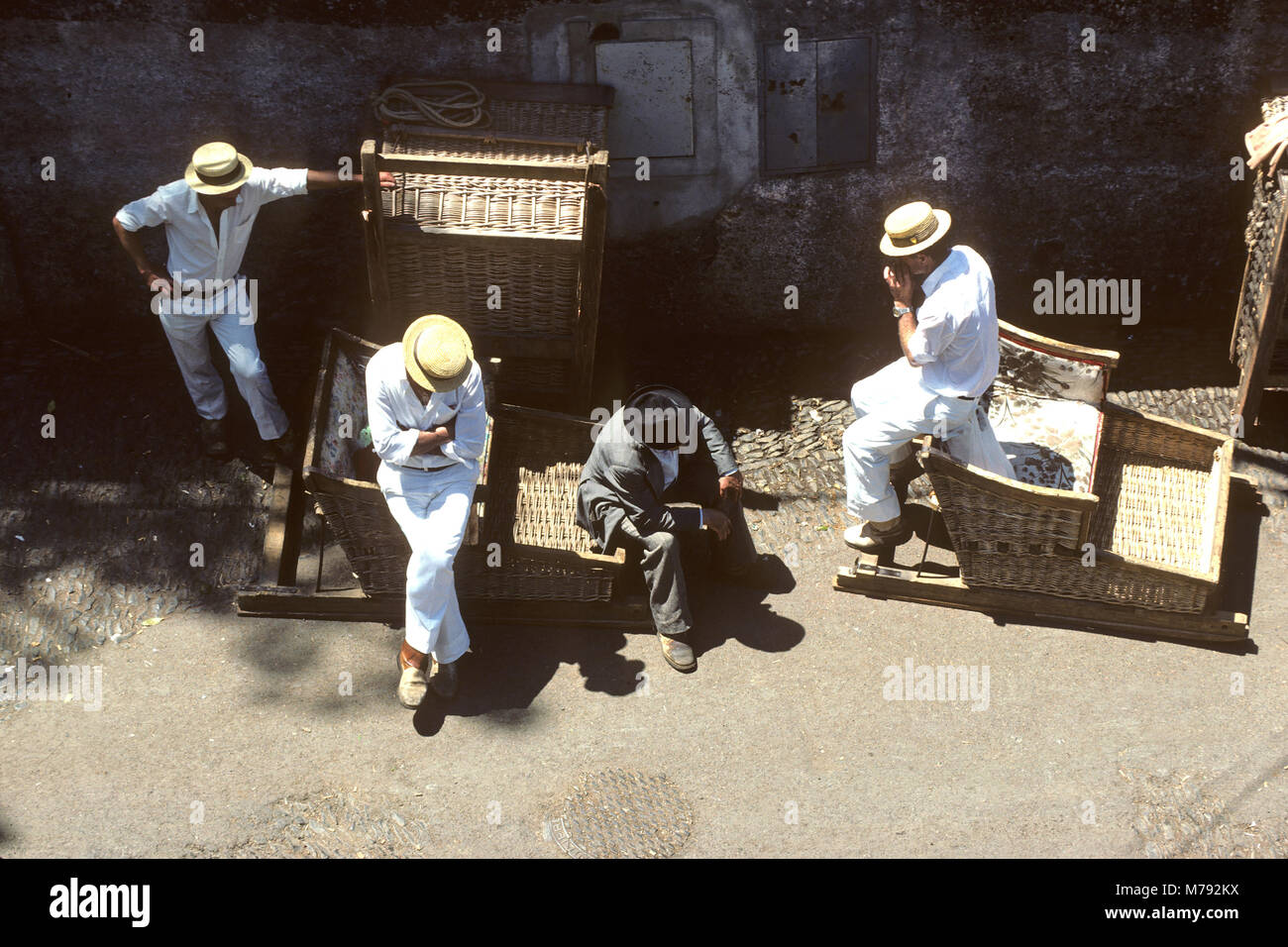 Toboggan basket ride workers on break in Funchal, Madeira, Portugal Stock Photo