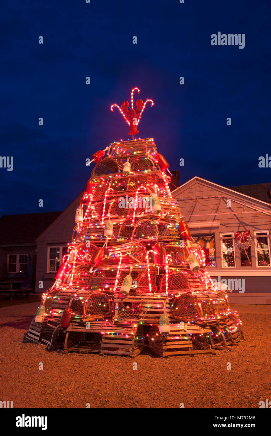 Brightly lit lobster trap holiday tree at dusk is a seacoast tradition in New England. Stock Photo