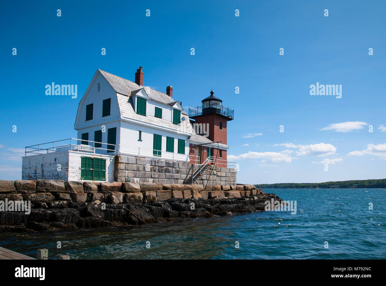 Rockland Breakwter lighthouse with its wooden building and brick tower, sits on the end of a breakwater on a summer day in Maine. Stock Photo