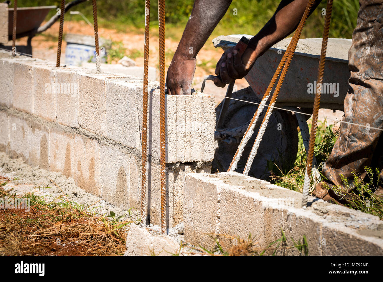Construction worker on site using trowel to spread wet cement from his