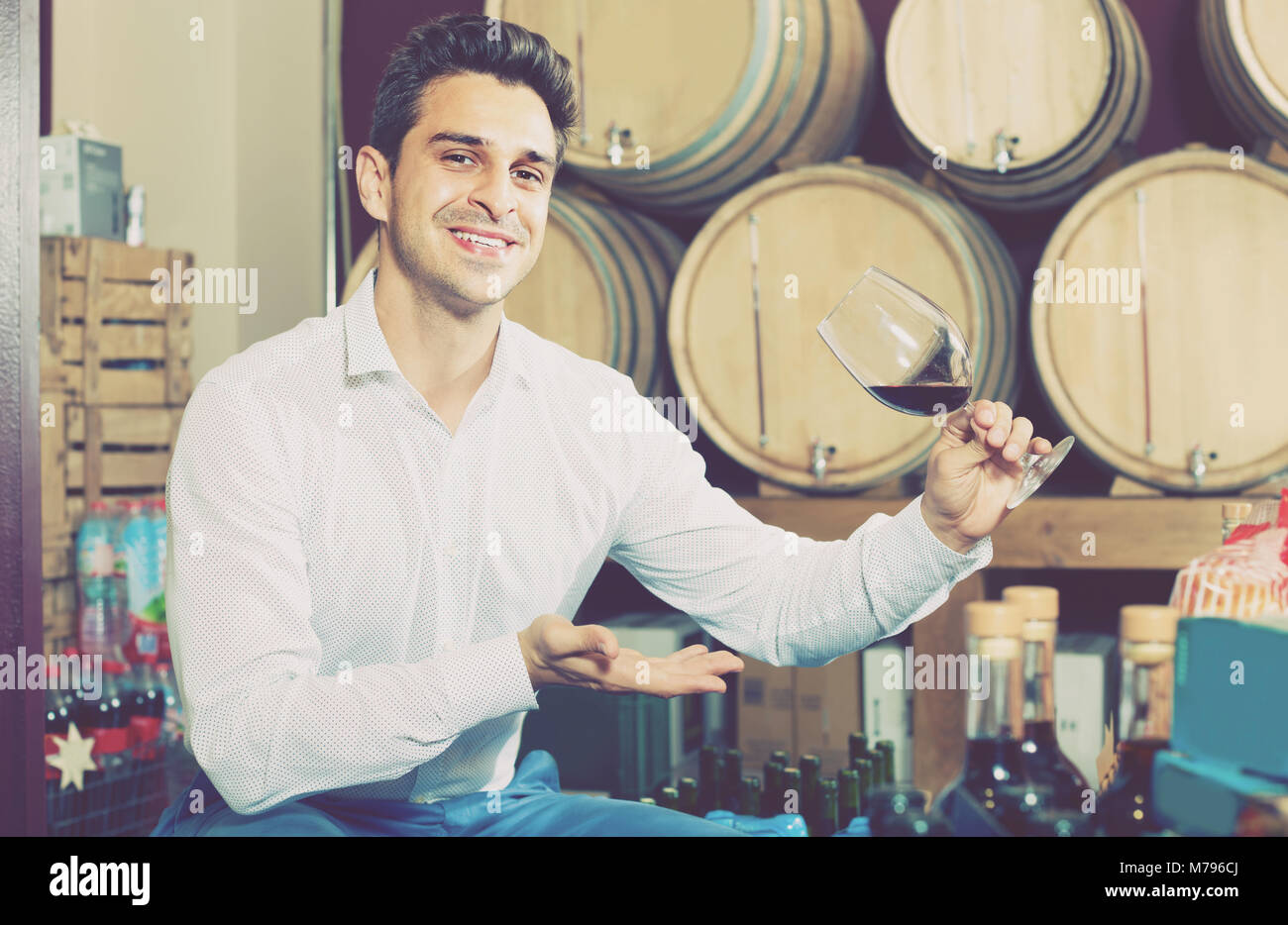positive adult man 40s having wine tasting in cellar with woods Stock ...