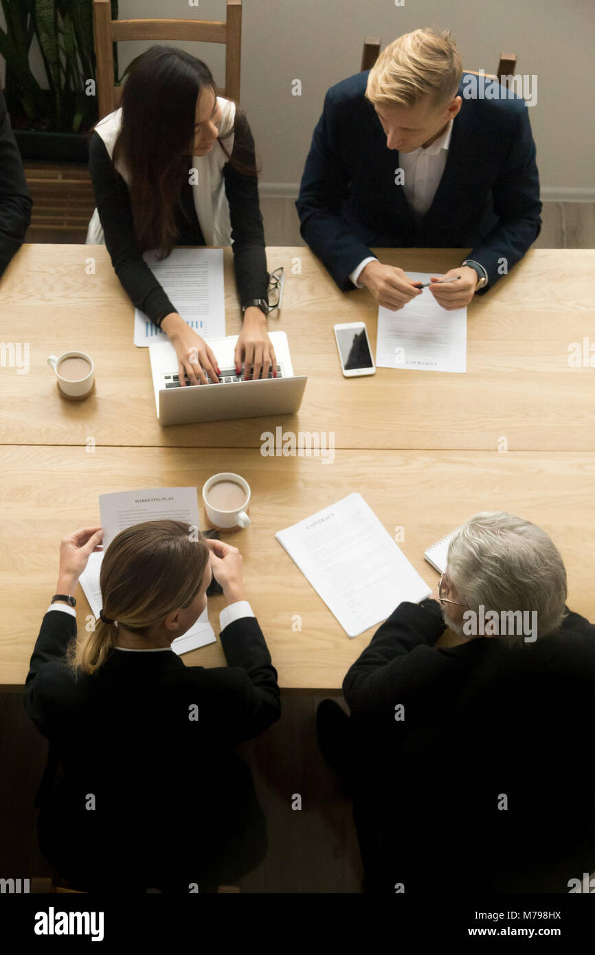 Diverse business colleagues working together at meeting, vertica Stock Photo