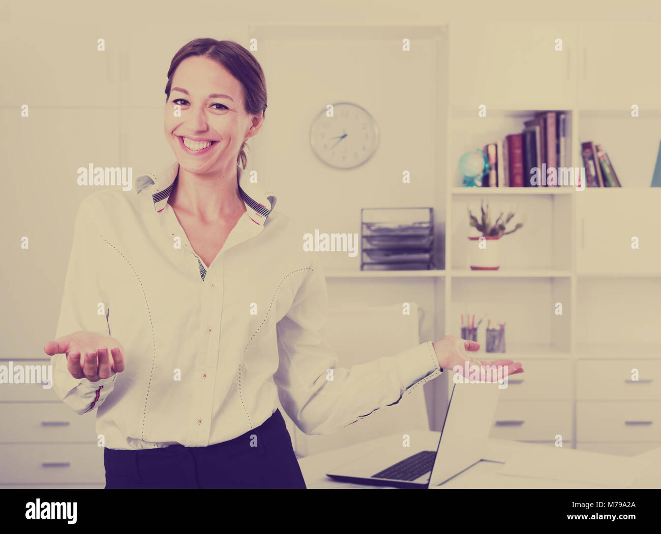happy young business woman in formalwear standing in company office ...