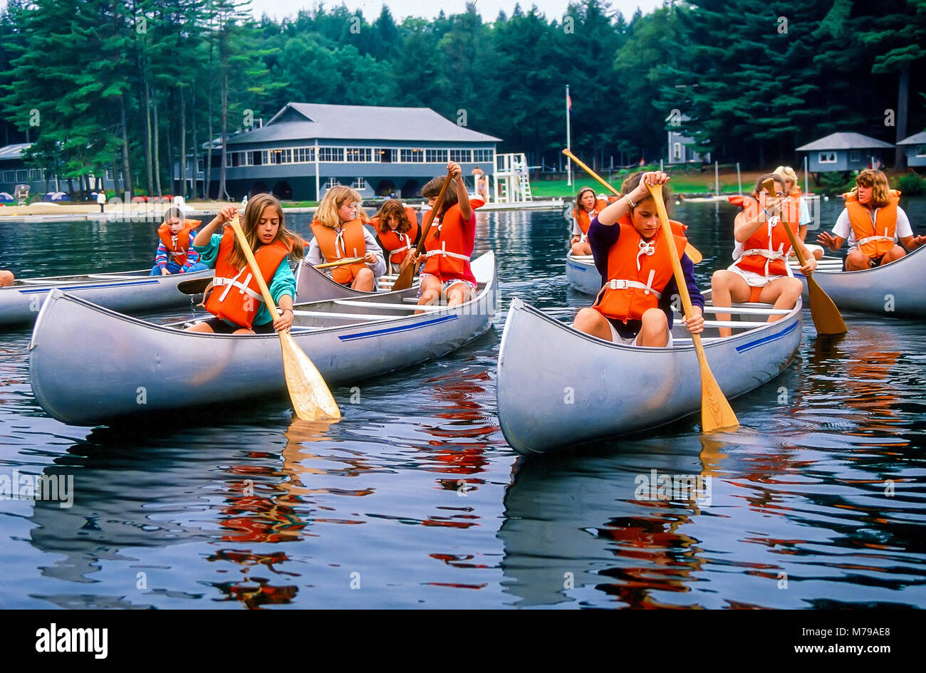 A large group of girls lean how to paddle canoes at summer camp in Vermont, United States, North America. Stock Photo