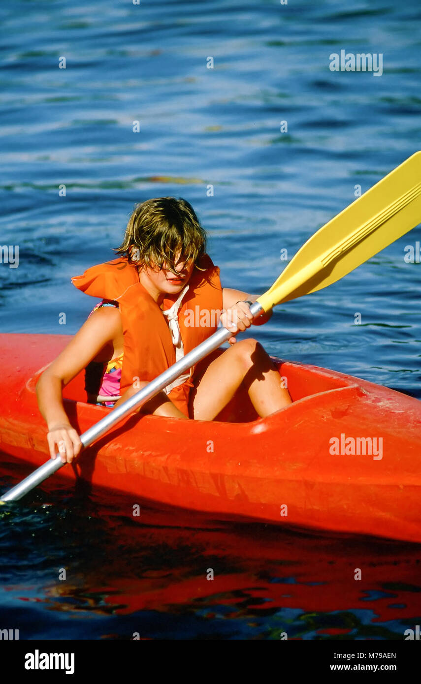 A 10-year old girl learns how to paddle a kayak at summer camp in Vermont, United States, North America. Stock Photo