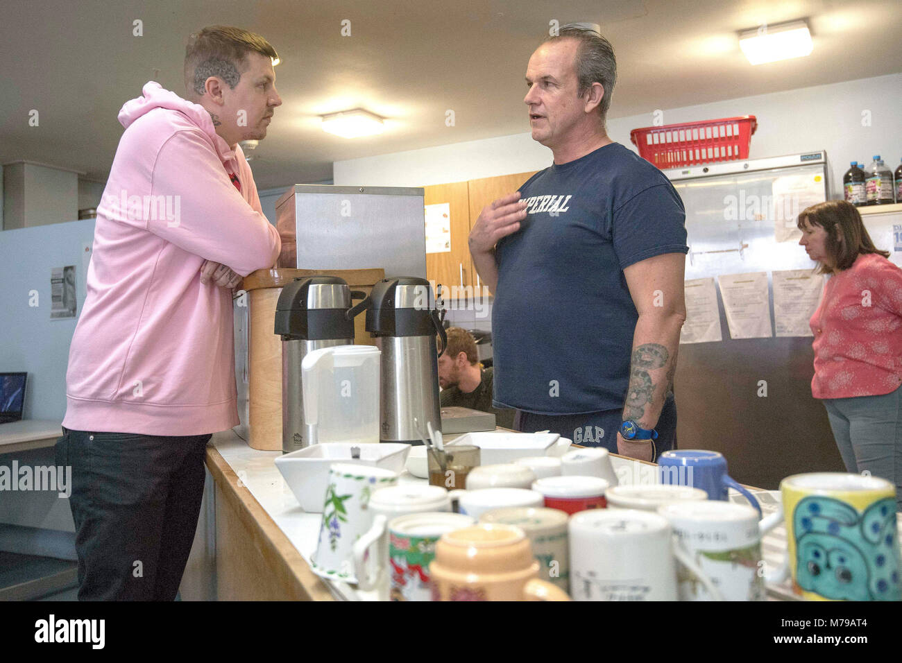 Rapper Professor Green meets a volunteer whilst visiting lottery-funded homeless charity 999 Club in Deptford, south London, to promote the National Lottery Awards. Stock Photo