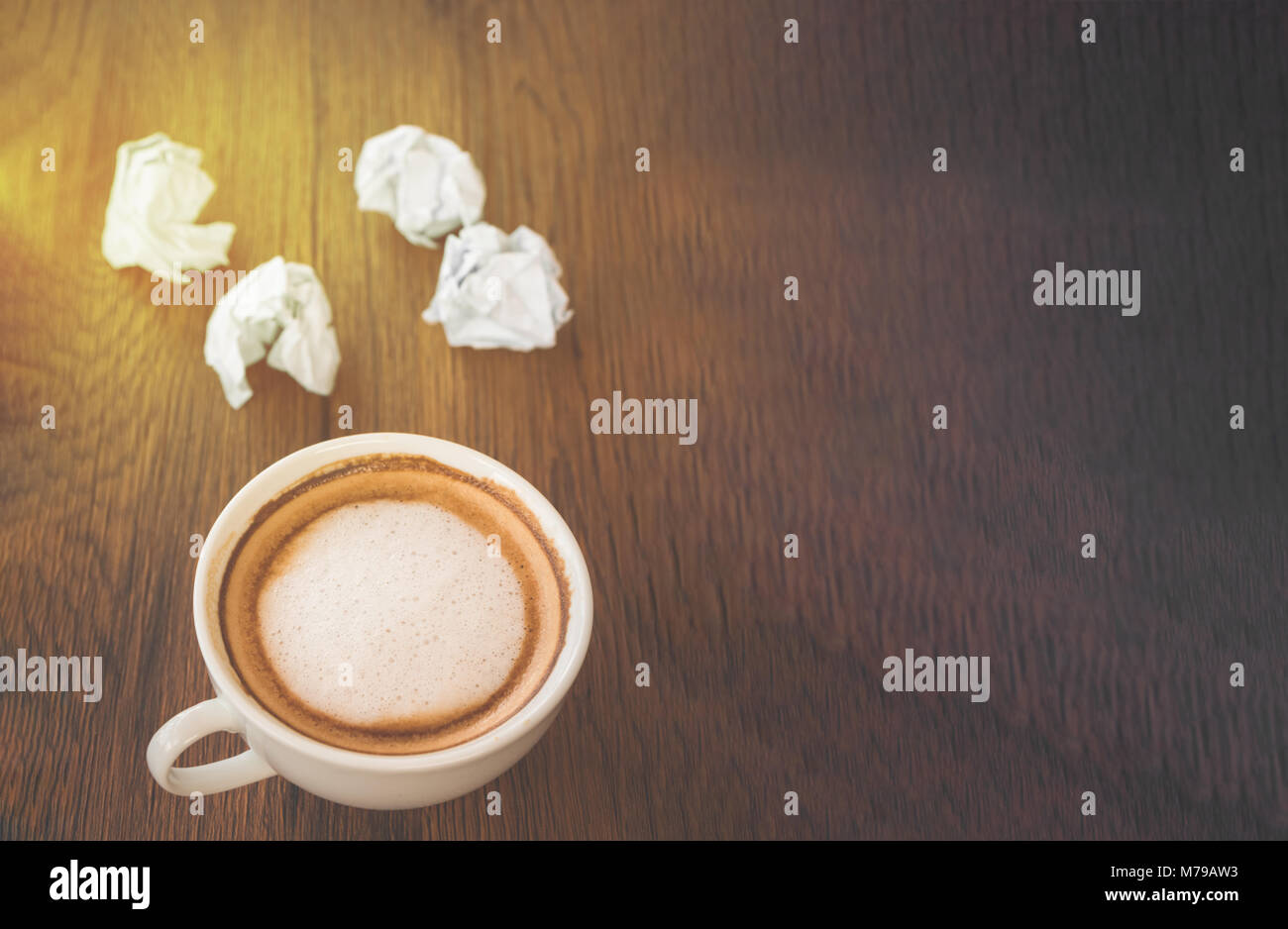 cup of coffee and crumpled paper on wooden table Stock Photo