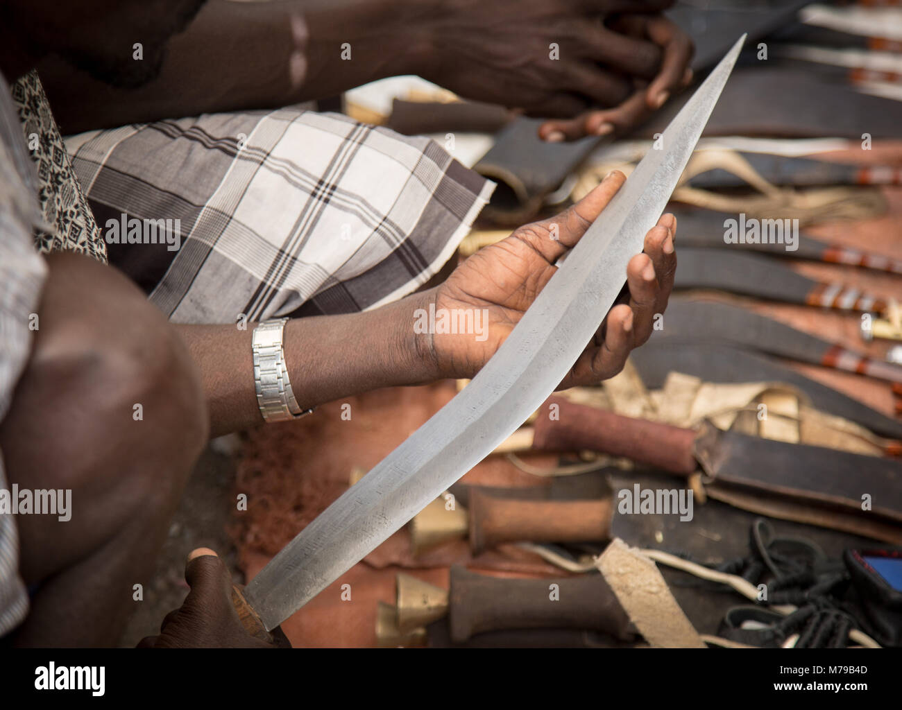 Sellers and buyers trying the merchandise at the knives market, Oromo