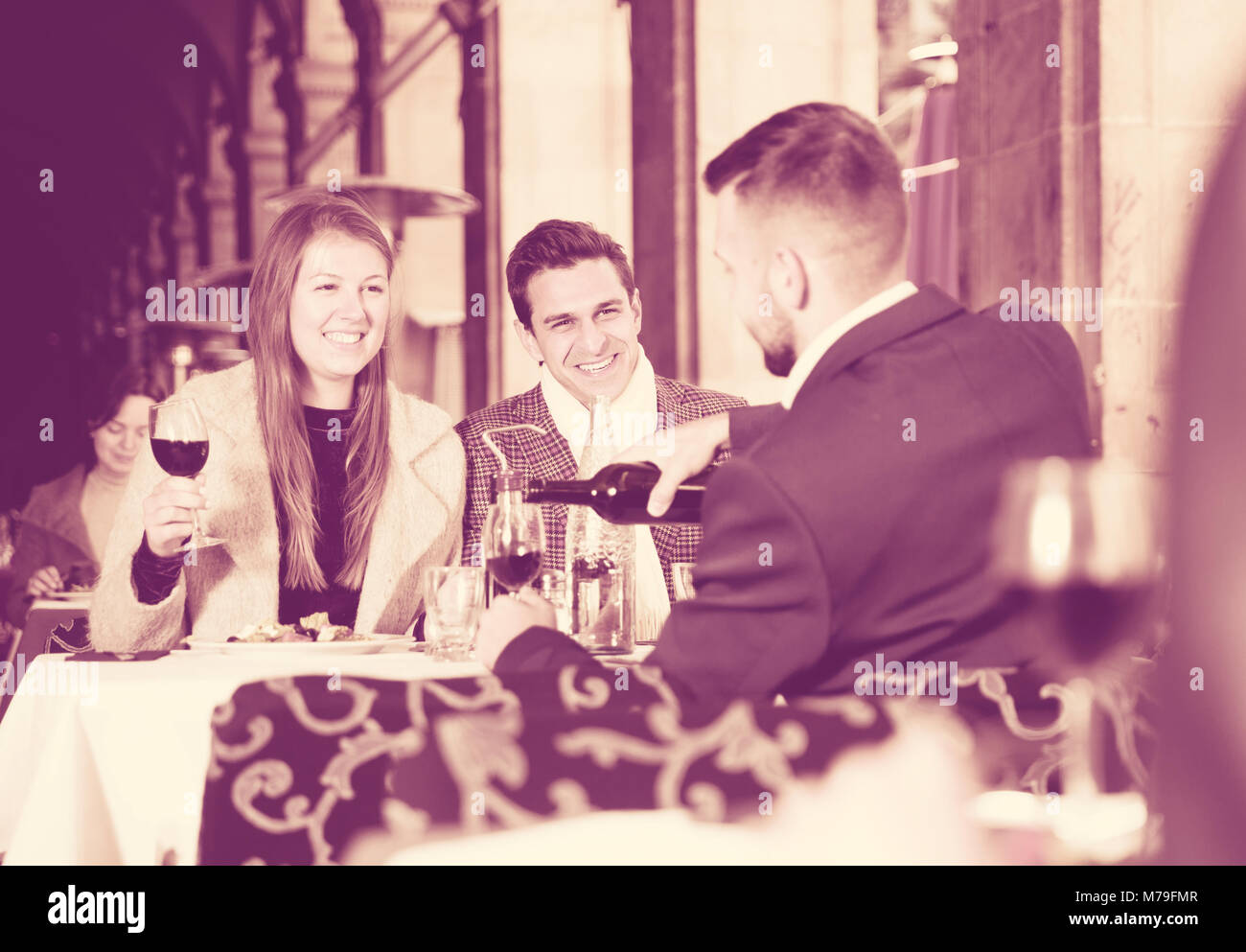 Friendly meeting over dinner with wine at terrace restaurant Stock