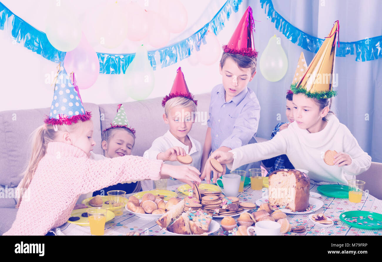 Smiling teenagers having dinner to celebrate friend’s birthday Stock