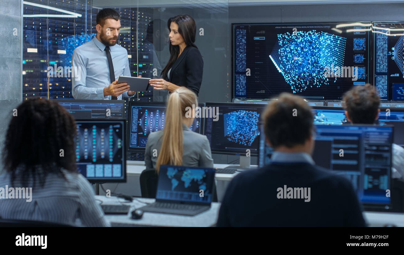 Head of the Department and Project Manager Discuss Work Process Using Data on Tablet Computer. Multi-Ethnic Team Builds Neural Network Stock Photo