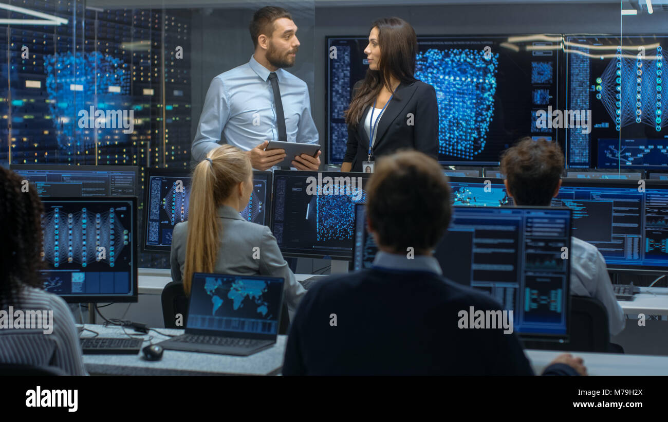 Head of the Department and Project Manager Discuss Work Process Using Data on Tablet Computer. Multi-Ethnic Team Builds Neural Network Stock Photo
