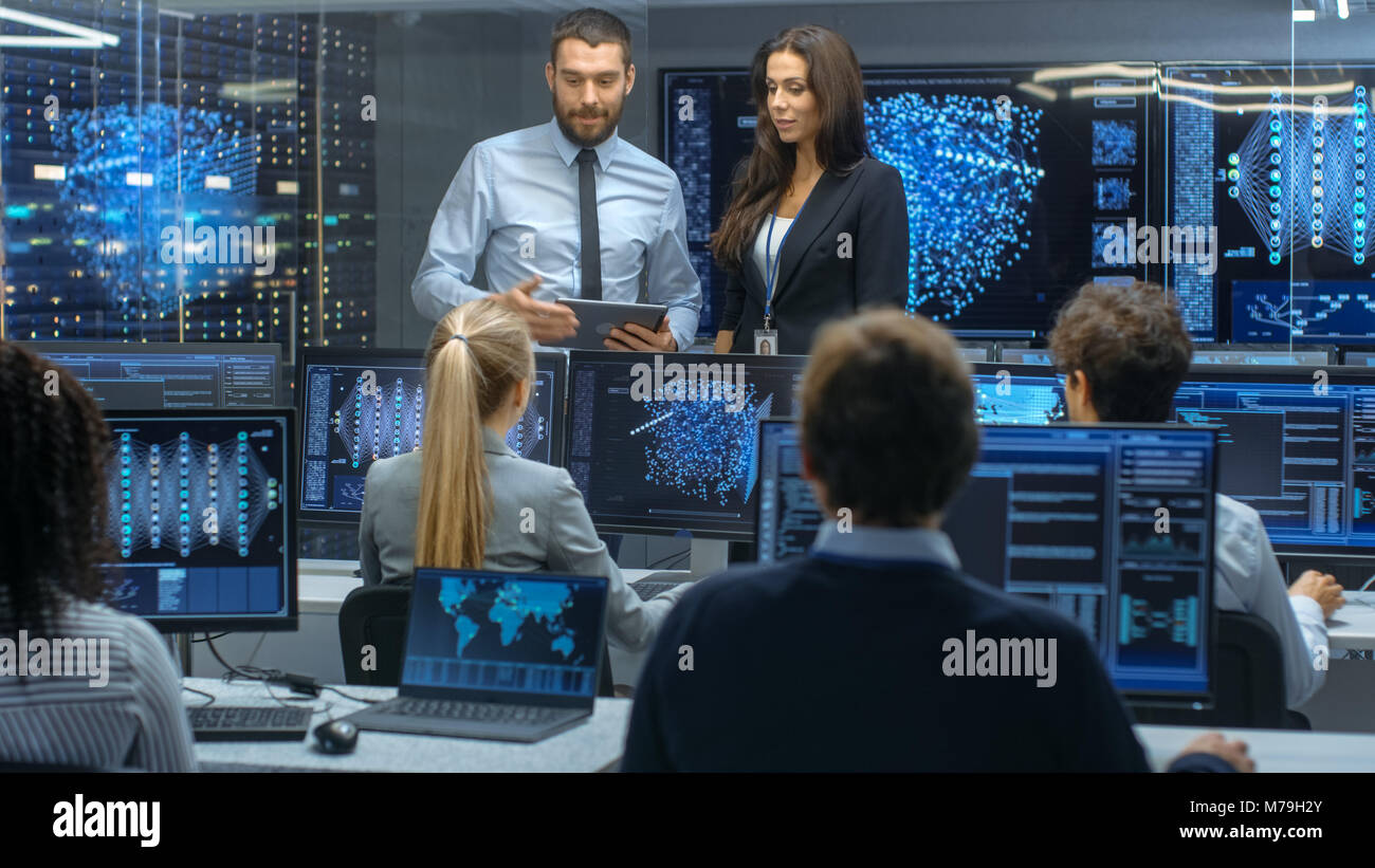 Head of the Department and Project Manager Discuss Work Process Using Data on a Tablet Computer.Multi-Ethnic Team of Engineers Working at Project. Stock Photo