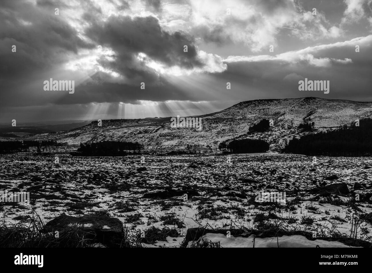 Sunbeams coming through the clouds on a snowy day, Burbage, Peak District Stock Photo