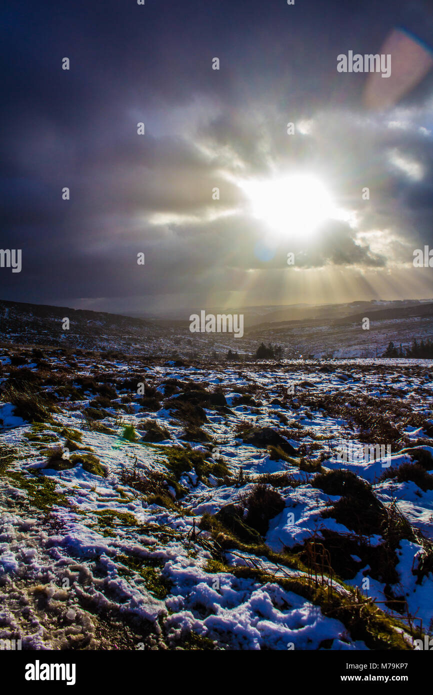 Sunbeams coming through the clouds on a snowy day, Burbage, Peak District Stock Photo