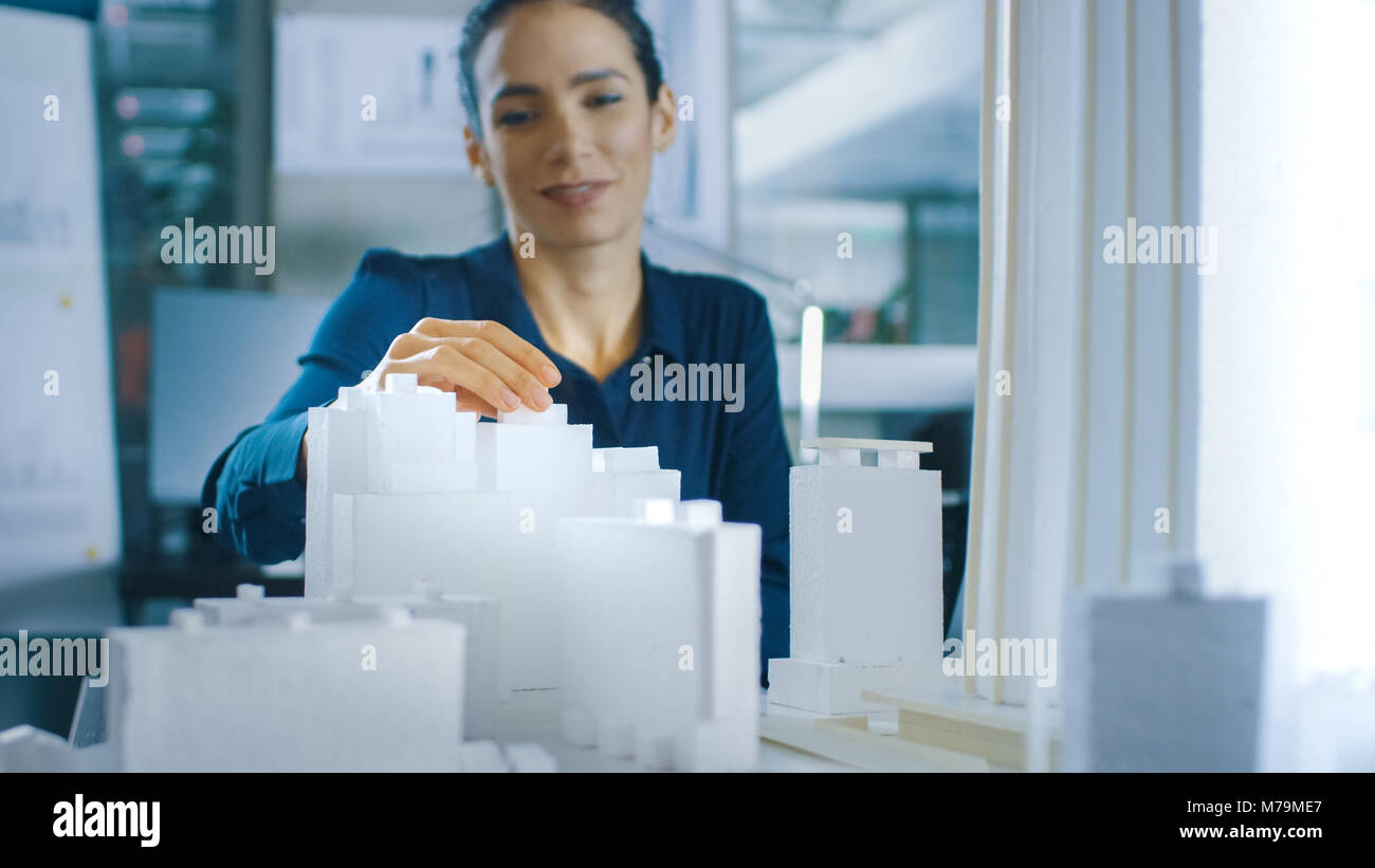 Female Architectural Designer Adds Component to a Building Model, She Works on a City District Urban Planning Project. Beautiful Woman in Office Stock Photo
