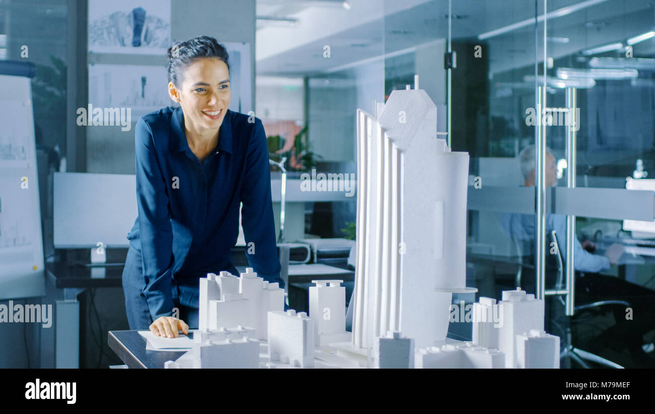 Long Shot of the Female Architectural Designer Adding Component to a Building Model, She Works on a City District Urban Planning Project. Stock Photo