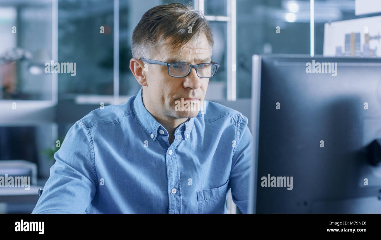 Chief Industrial Engineer Working on Personal Computer in the Stylish, Modern, Glass Office. Stock Photo