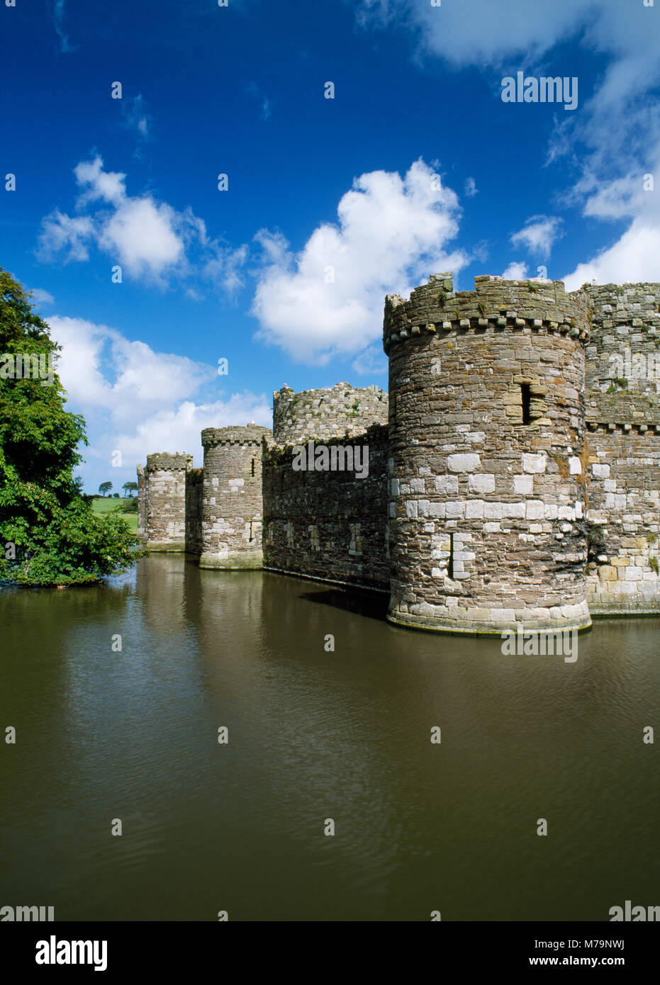 Looking northwards across the moat at the south west tower and outer curtain wall of Edward I's castle. Beaumaris, Anglesey, North Wales. Stock Photo