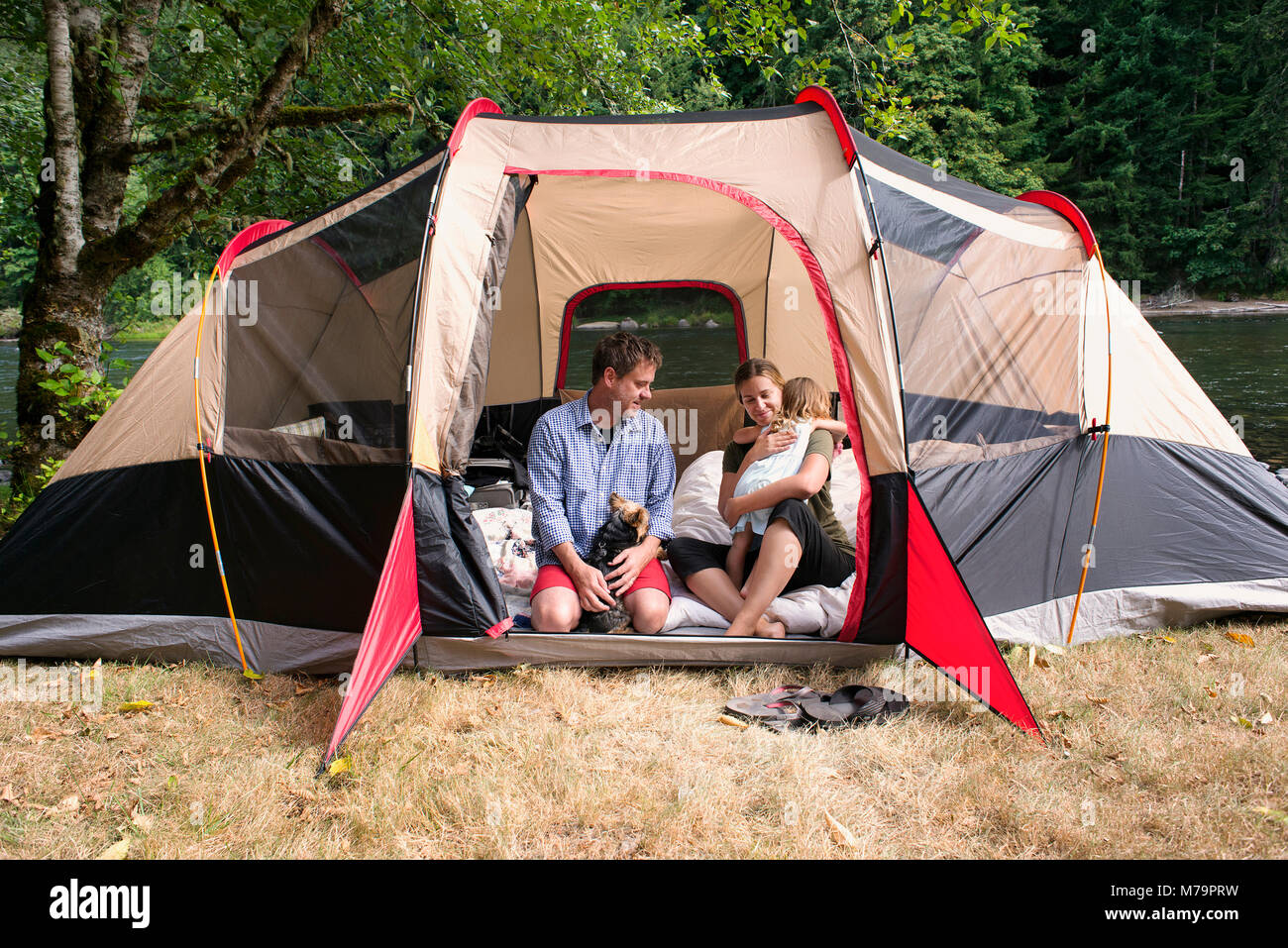 A family hanging out in their tent along the Santiam river in Oregon. Stock Photo