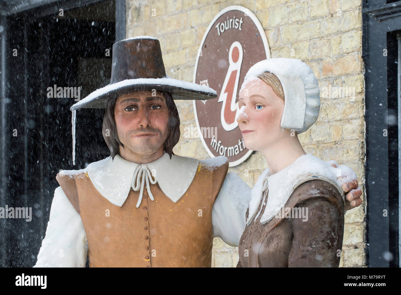 Figures of a man and woman outside Oliver Cromwell house in falling snow, Ely, Cambridgeshire, England Stock Photo