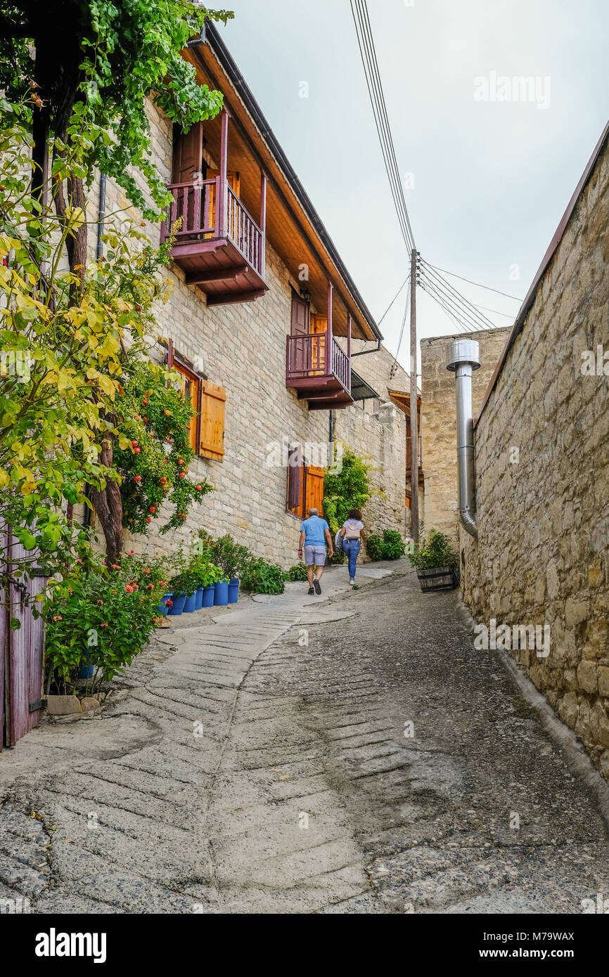 Man and woman walking up a very steep narrow road in a Cypriot village. Stock Photo