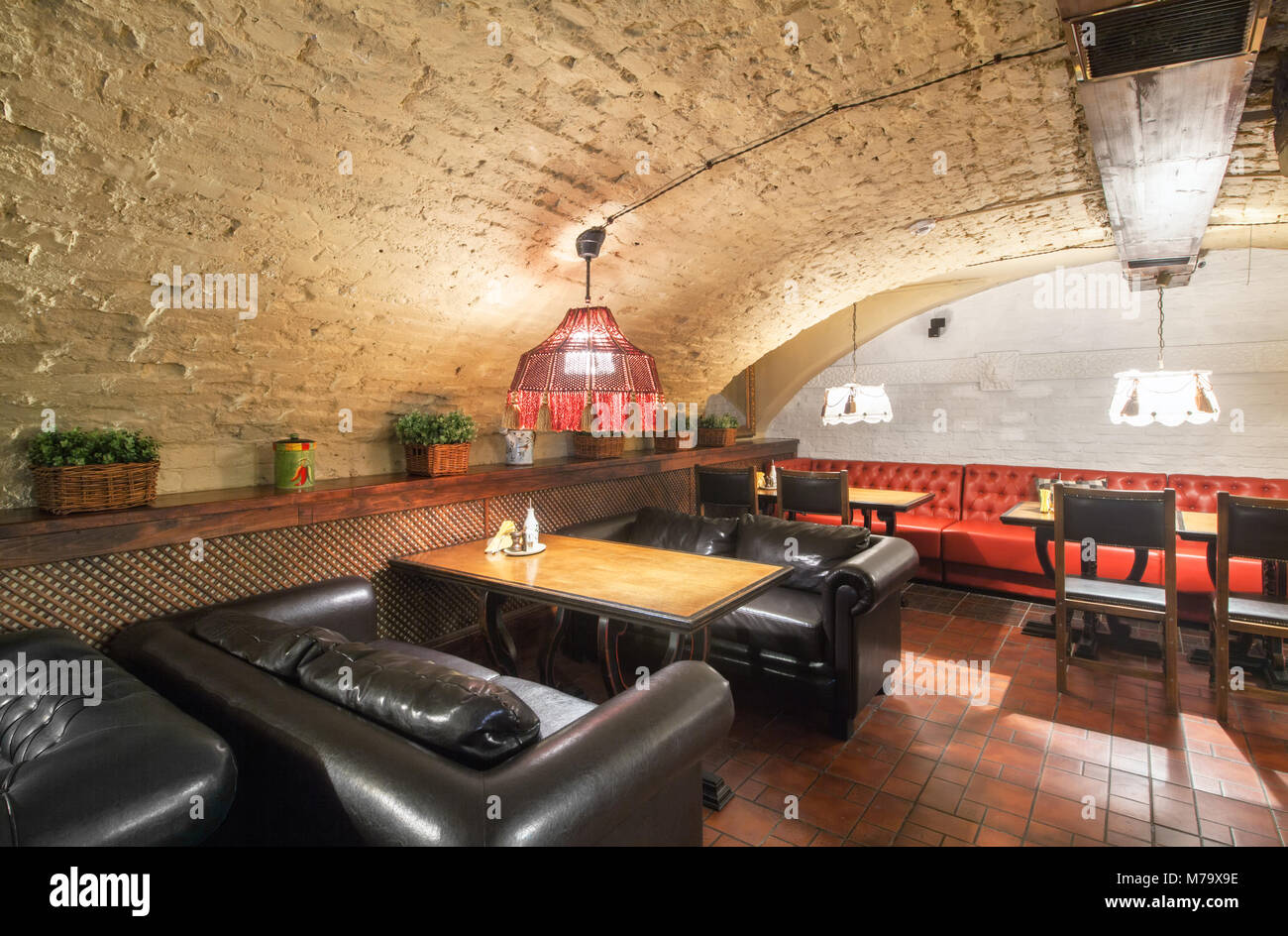 MOSCOW - AUGUST 2014: Interior of a luxury restaurant "PEPPE" in the historic cellar with brick vault. Tables with leather sofas Stock Photo