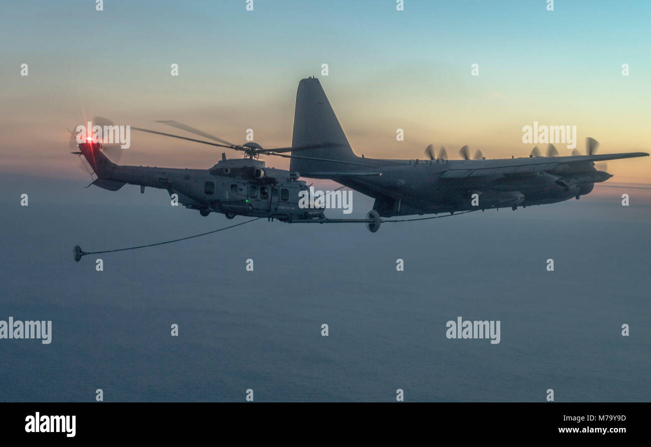 A NATO Air Force EC-725 Super Cougar receives fuel from a U.S. Air Force C-130 Hercules as part of Emerald Warrior over the Gulf of Mexico March 2, 2018. At Emerald Warrior, the largest joint and combined special operations exercise, U.S. Special Operations Command forces train to respond to various threats across the spectrum of conflict. (U.S. Air Force photo by Staff Sgt. Trevor T. McBride) Stock Photo