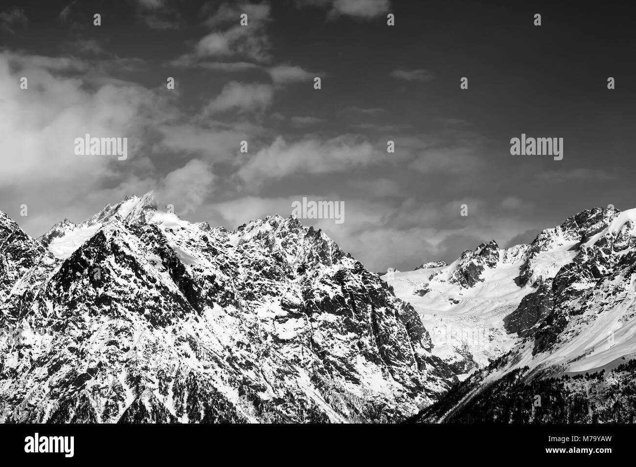 Snowy rocks at sunny day. View from chair lift on Hatsvali, Svaneti region of Georgia. Caucasus Mountains. Black and white toned landscape Stock Photo