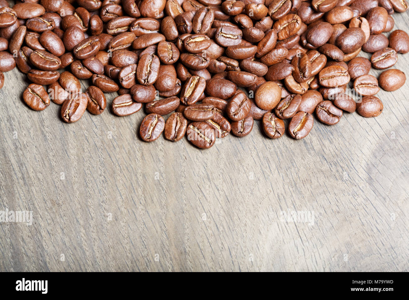 Fresh coffee beans on wood, ready to brew delicious coffee. Stock Photo